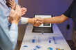 © crizzystudio - Businesswomen shaking hands after successful presentation in office meeting