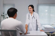 © crizzystudio - Female doctor shaking hands with patient in hospital room