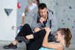 © auremar - man checking on woman who fell of climbing wall