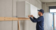 © Aksaka - Man installing white wall cabinets in a room