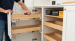 © Aksaka - Pulling out kitchen cabinet wooden drawers
