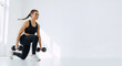 © Milan - Fit woman doing lunge exercise with dumbbells in a white studio. Strength training and workout for a healthy lifestyle. Copy space for text