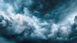 © NingPhattraphorn - A dramatic sky filled with dark, churning storm clouds in shades of deep blue, grey, and white, suggesting powerful, impending weather, blurred blue background