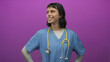 © Krakenimages.com - Woman nurse with stethoscope in blue scrubs stands hands on hips smiling with freckled cheeks in studio; confidence.