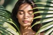 © Dima Anikin - A tranquil and serene portrait of a young woman beautifully captured amidst the vibrant, lush tropical foliage