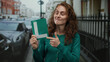 © Krakenimages.com - Woman smiling on city street holding learner sign confidently exhibits her excitement and readiness for driving with urban background.