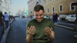 © Krakenimages.com - Young man smiling on urban street with people and cars in background, showcasing a lively city atmosphere