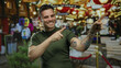 © Krakenimages.com - Young man with tattoos smiling and pointing at a festive outdoor market setting.