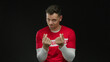 © Krakenimages.com - Young man in red shirt making money gesture against black background showcasing humor and charisma with expressive facial expressions and hand movements