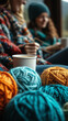 © Анастасія Шестопал - Bright colorful balls of knitting yarn are neatly arranged with blurred figures crafting and relaxing indoors with warm beverages.