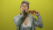 © Krakenimages.com - Woman with short grey hair wearing a grey hoodie and white top pointing finger and holding waffle in yellow studio; fun.