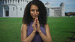 Woman with curly hair smiling in front of pisa tower in italy showcasing joyful moment outdoors.