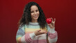 © Krakenimages.com - Woman holding red heart and showing thumbs up on an isolated red background, expressing positivity and love in a cheerful, colorful setting, perfect for valentine promotions.