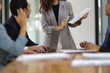 © Wasan - Asian businesswoman leader discussing business planning idea presentation with colleagues in conference room at office.