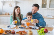© InsideCreativeHouse - Caucasian family enjoy a cheerful breakfast together in modern kitchen. Family of three with son sharing a joyful morning meal around the kitchen island enjoying tasty food and drinking orange juice