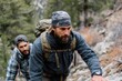 © Denis Tuev - Two men, one with a backpack and the other in a plaid shirt, are climbing a rocky mountain trail, showcasing determination and teamwork in an outdoor adventure setting