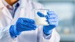 © chusnul - Scientist in a lab wearing gloves holds a glass beaker with milk, showcasing research in a clean environment
