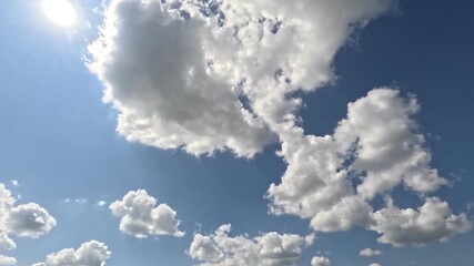 Wall Mural - Incredibly beautiful grey cumulus textured clouds under blue sky on partly cloudy day with shining sun. Timelapse mode.
