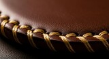 Close-up of rich brown leather with hand-stitched braided golden thread detail, highlighting intricate craftsmanship and textured surface.