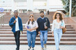 © Serhii - Diverse students walking on campus building stairs