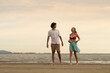 © Montri - Happy young couple enjoying playful piggyback ride at the beach during sunset. Perfect for concepts like romance, summer vacation, freedom, fun, and relationship lifestyle imagery.