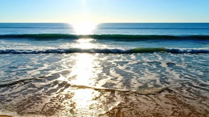Wall Mural - Dynamic timelapse of sunlight creating shimmering patterns on gentle ocean waves washing a beach shimmer, bright, water