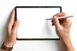© Jasmine - Overhead view of a person's hands holding a modern digital tablet with a blank white screen and a stylus pen.