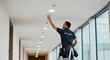 © Margarita Ratatosk - Safety technician man installing a smoke alarm detector on the ceiling of a modern building. Fire protection and maintenance service concept.