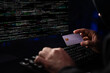 © InfiniteFlow - Cropped hands image in criminal anonymous male approaching credit card of personal information database for codding encryption scam program in privacy system at night at blue neon light room. Surmise.