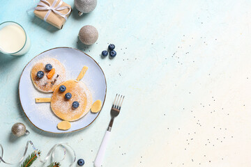Wall Mural - Plate with pancakes in shape of snowman on light background. Christmas celebration