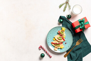 Wall Mural - Plate with pancakes in shape of Christmas tree on light background