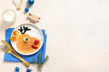 Wall Mural - Plate with pancakes in shape of Santa reindeer on light background