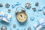 Alarm clock and Christmas decor on blue background. Top view