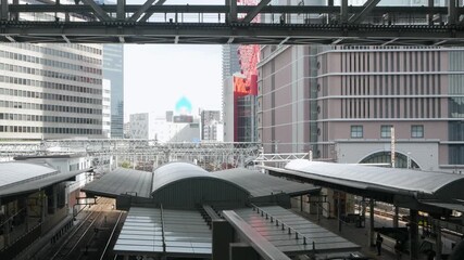Wall Mural - aerial landscape view inside railway station in osaka, japan in open air area with commuter train pu