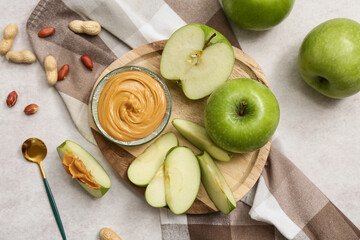 Wall Mural - Wooden plate with fresh apples and bowl of sweet peanut butter on white background