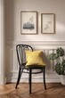 © duta - Two framed prints, featuring line drawings of plants, adorn a light beige wall, complemented by a black chair with a mustard-yellow cushion and a decorative plant.