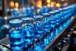 © smartcat - Close-up view of multiple transparent glass vials filled with blue liquid lined up on a conveyor belt in a sterile industrial setting under warm lighting