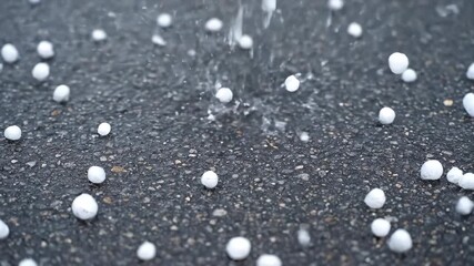 Wall Mural - Rapid-fire close-up of hail stones intensely bouncing and scattering upon a hard, dark pavement surface, with crisp, sharp sound suggested by motion water, storm, meteorology