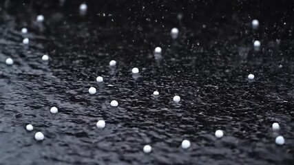 Wall Mural - Rapid-fire close-up of hail stones intensely bouncing and scattering upon a hard, dark pavement surface, with crisp, sharp sound suggested by motion texture, motion, water