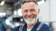 © Babb - A cheerful mechanic stands in a well-lit garage filled with cars. He wears a blue uniform and appears happy showcasing his professionalism and dedication to his work.