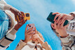 © Dani D.G - Diverse young friends actively engaging with smartphones. Capturing moments and sharing digital content. Representing youth culture. Social media connection