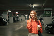 © Prathankarnpap - Young Asian woman having a phone conversation in an indoor parking garage