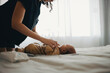 © Jacob Lund - Mother cares for baby on bed in natural light