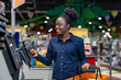 © Liubomir - Young black woman scanning groceries and paying with a smartphone at a supermarket self-checkout, smiling while using contactless nfc for fast, convenient retail shopping