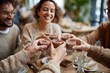 © Yevheniia - Smiling friends toasting with hot chocolate in cozy café gathering