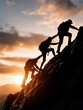 © RMedia - A chain of silhouetted hikers helping each other climb a steep, rocky mountain ridge at sunset, symbolizing teamwork and challenge.