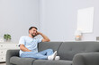 © New Africa - Happy man resting on sofa at home. Space for text