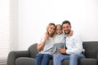 © New Africa - Happy family spending time together on sofa at home. Space for text