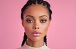 © Surachetsh - A stylish African American woman with braided hair poses before a pink background, highlighting natural beauty, glowing skin, and modern makeup.