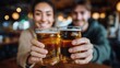 © liliyabatyrova - Couple celebrates at a bar while raising their beer glasses in a joyful toast during a lively evening